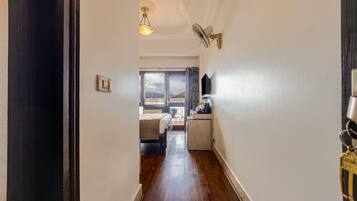 Un pasillo con una cama, una pequeña kitchenette y vistas al exterior.