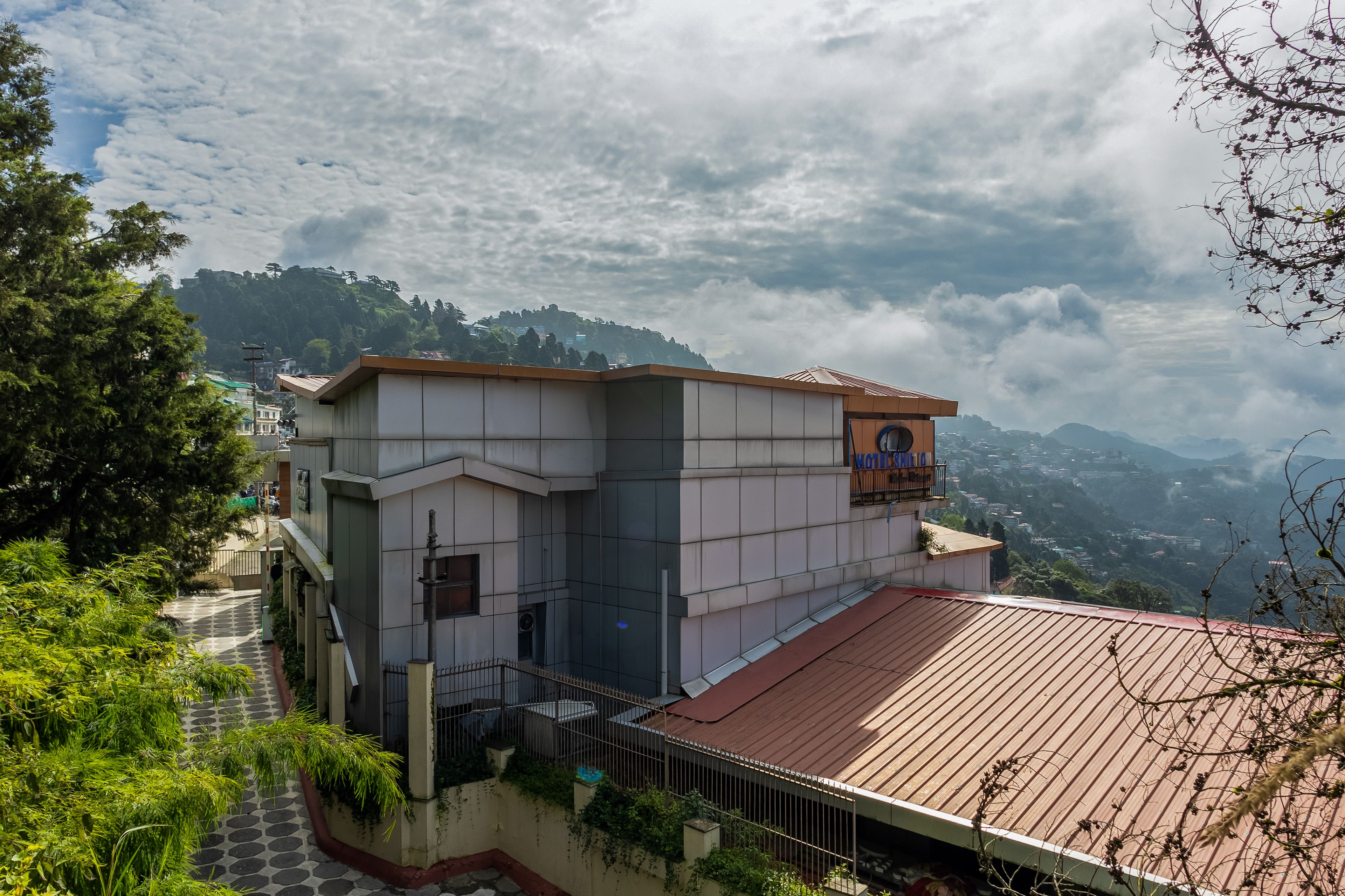A hotel with a modern design, located on a hillside with a view of the surrounding landscape.