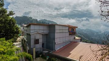 A hotel with a modern design, located on a hillside with a view of the surrounding landscape.