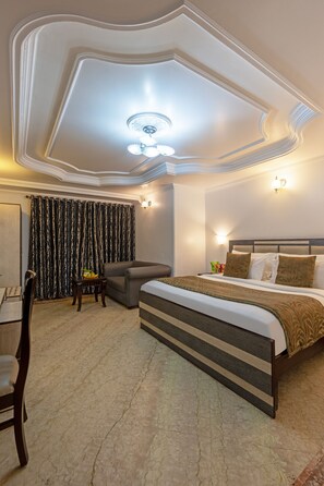 Una habitación de hotel con una cama grande, un escritorio y una silla.