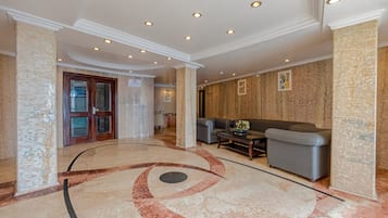 A lobby with a marble floor, a reception desk, a sofa, and a door labeled 'RECREATION'.