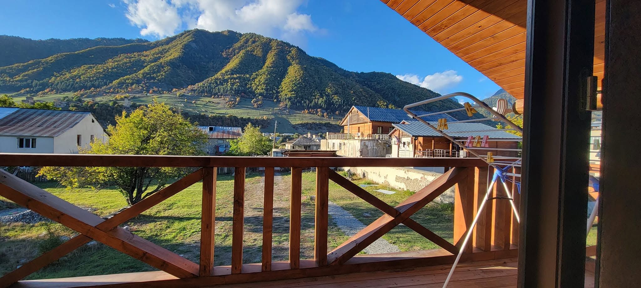 A wooden deck with a view of a mountain and a village.