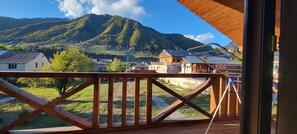 A wooden deck with a view of a mountain and a village.