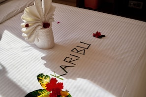 A neatly made bed with a towel folded on it and a name tag spelling 'KARIBLI' on the bedspread. - Exclusive 3-Bedroom Beachfront Villa with Private Pool in Zanzibar (Zanzibar)