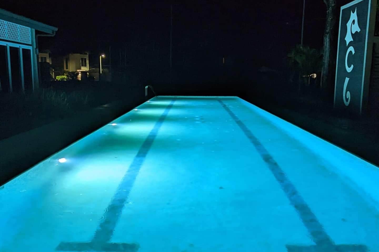 Ein Pool bei Nacht mit blauer Beleuchtung.