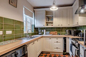 Una cocina con pileta, estufa y placares.