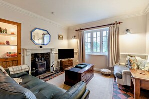 Una sala de estar acogedora con chimenea, televisor y un espacio de descanso cómodo.