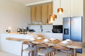 A modern kitchen with a central island, stainless steel appliances, and pendant lighting. - Dolce Vita - Tropical Poolside Paradise (Sint Michiel)