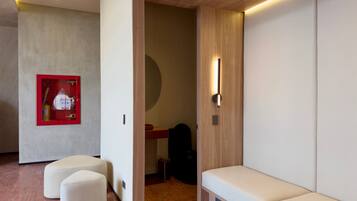 Een modern interieur met een zithoek, een rode brandblusser en een houten wand.