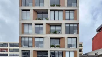 A multi-story building with balconies, large windows, and a flat roof.