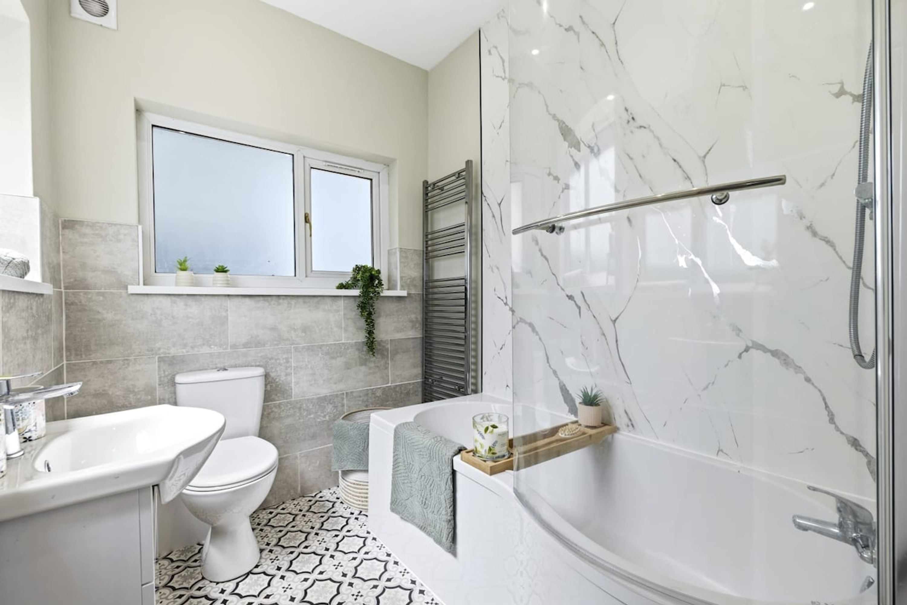 A bathroom with a bathtub, toilet, and sink.
