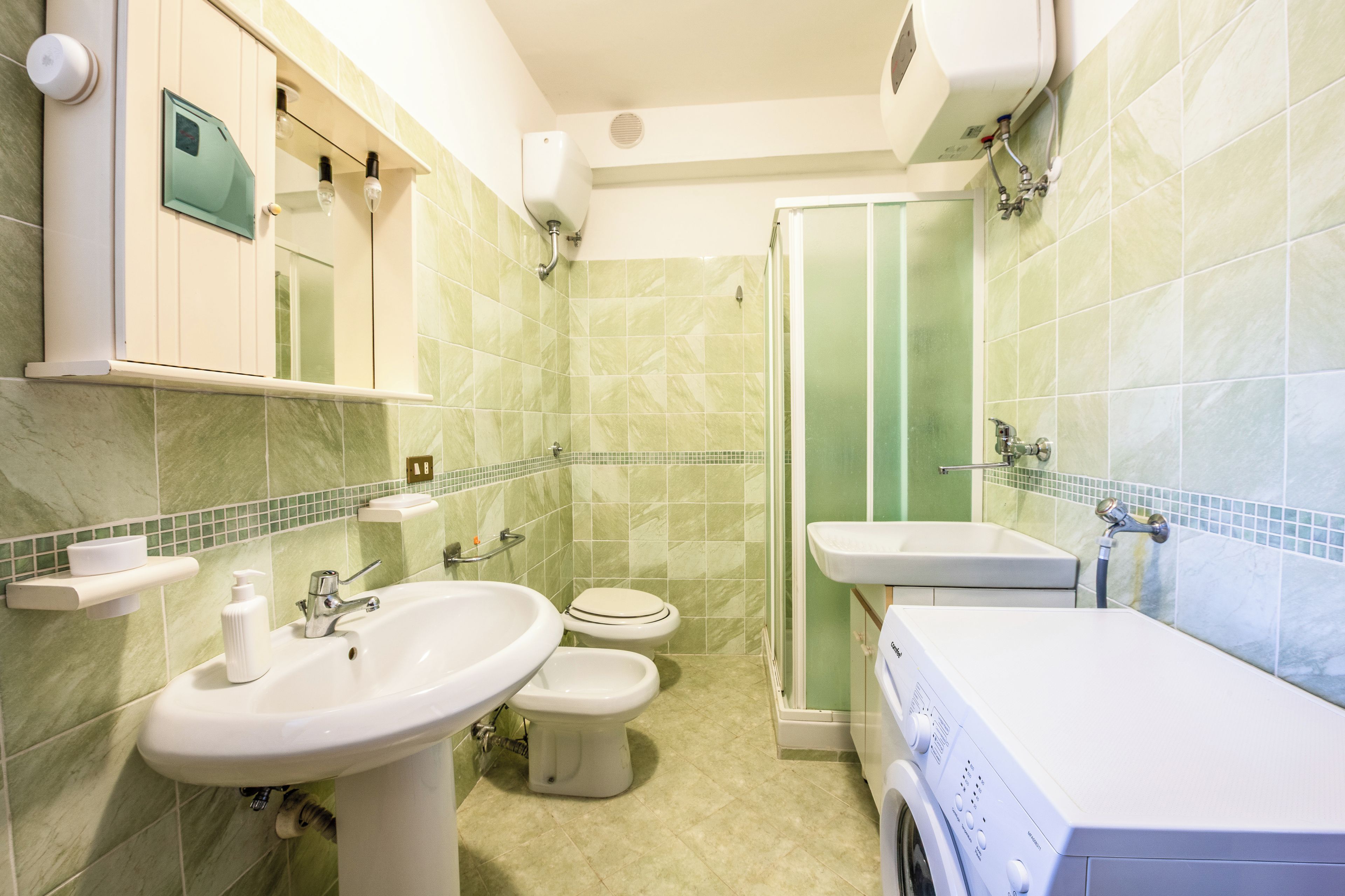 A bathroom with a sink, toilet, and shower.