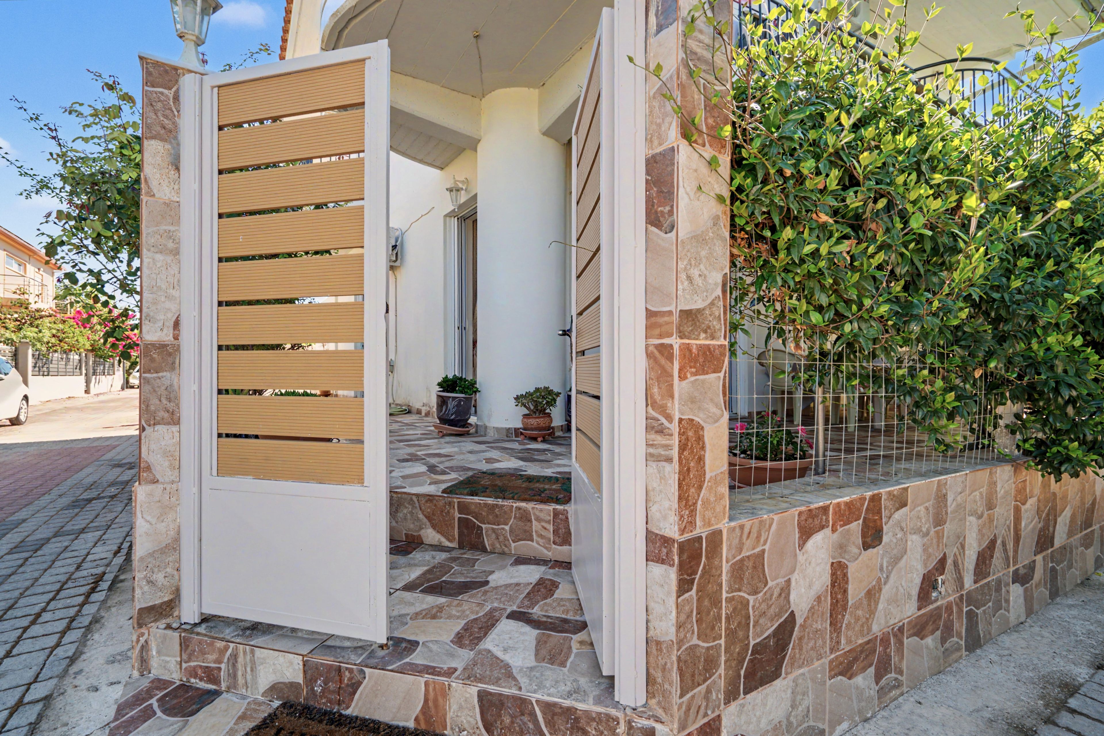 A gated entrance with a stone pathway leading to a building.