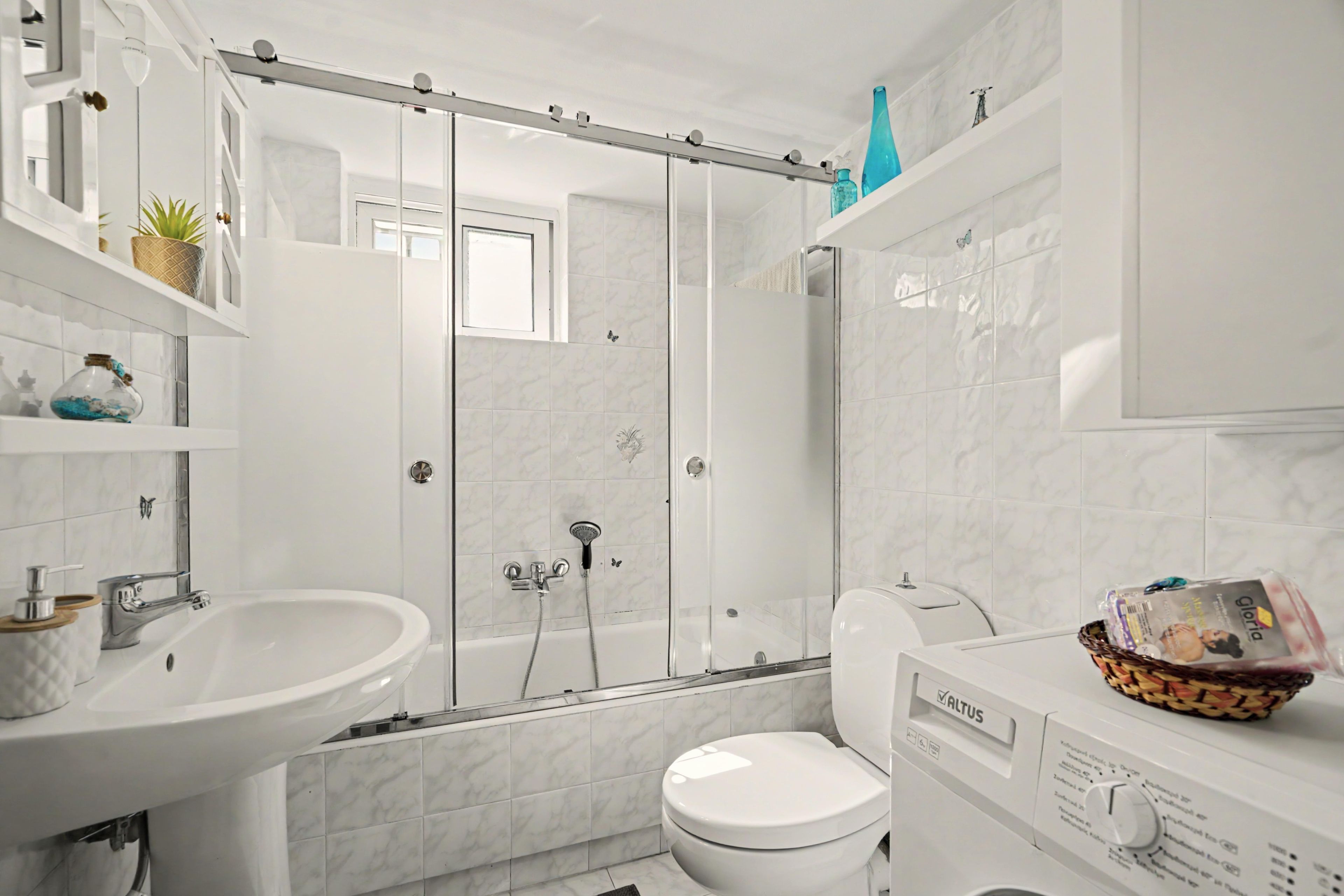 Een moderne badkamer met douche, toilet en wastafel.