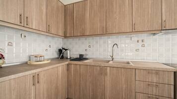 A kitchen with wooden cabinets, a sink, and a tiled backsplash.