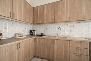 A kitchen with wooden cabinets, a sink, and a tiled backsplash.