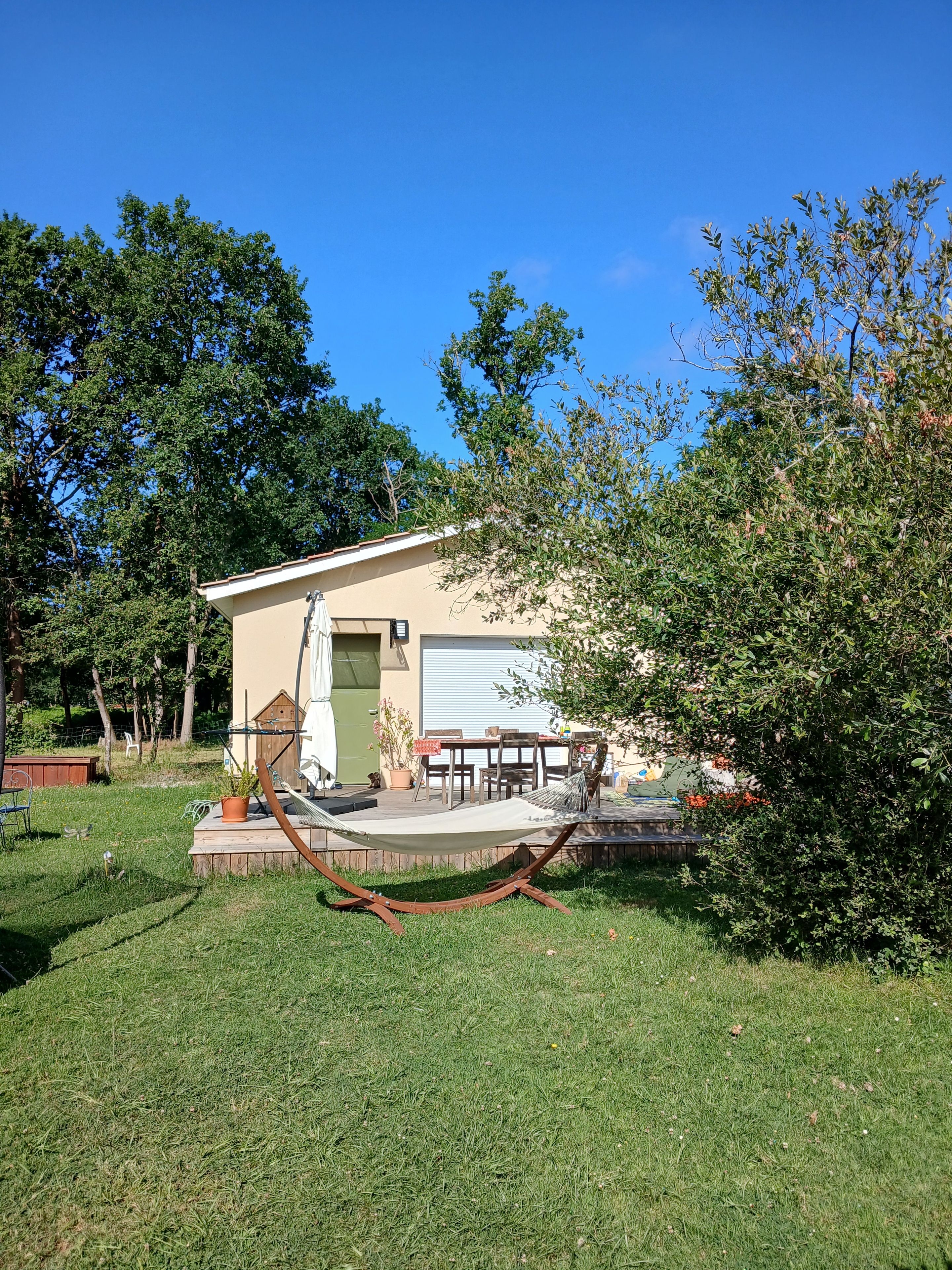 A house with a patio, a hammock, and a small deck.