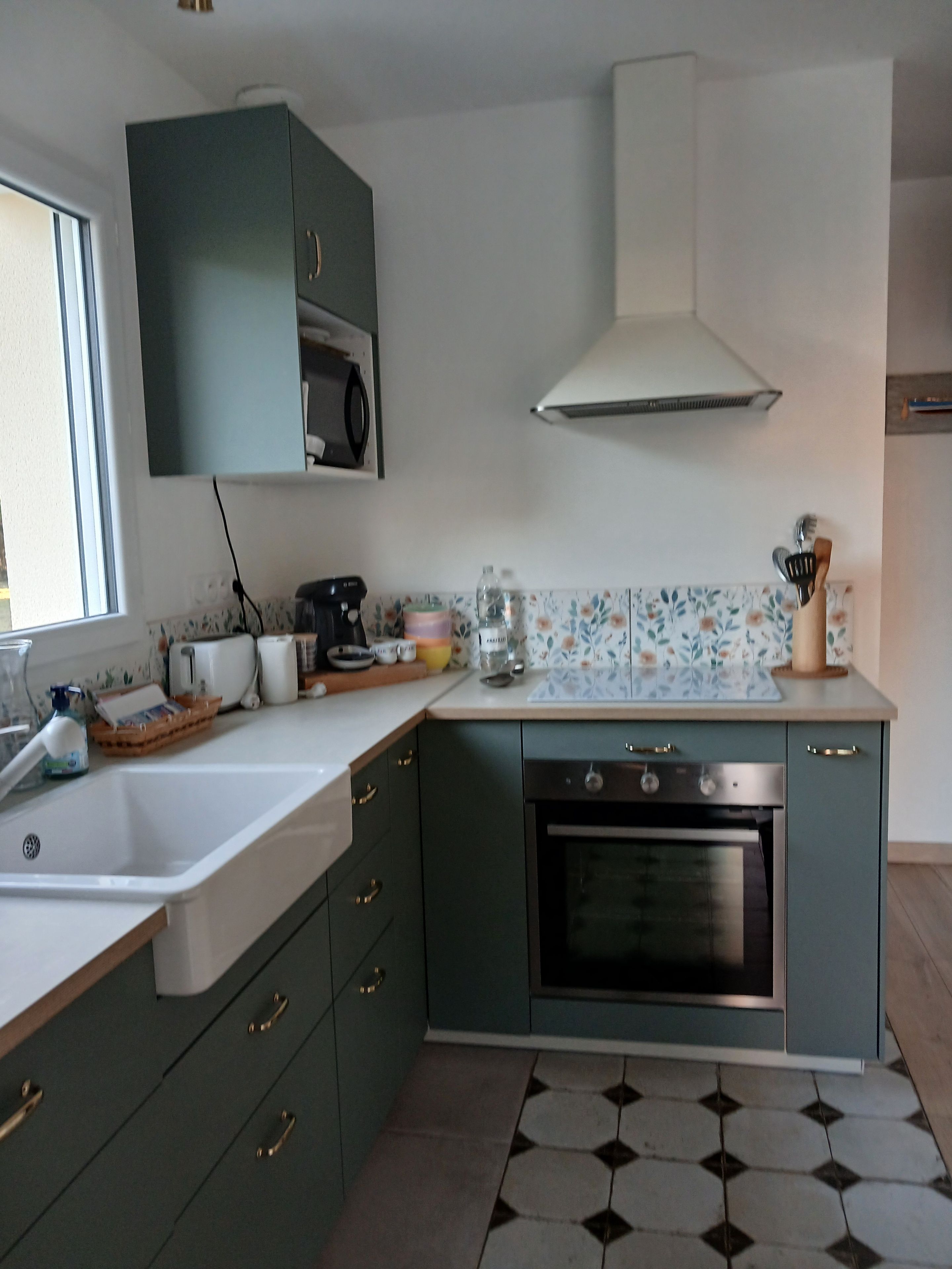 Una cocina equipada con horno integrado, un lavabo y un microondas.