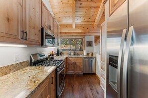 A kitchen with wooden cabinets, stainless steel appliances, and a granite countertop. - Indian Hills Charming Townhome 3 Bedroom Townhouse (Truckee)