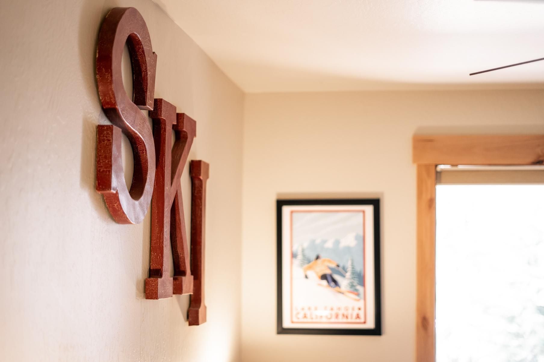 A wall with wooden letters spelling 'SKI' and a framed picture of a skier.