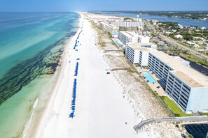 Eine Luftaufnahme eines Küstenhotels mit langer Strandpromenade, mehreren Gebäuden und einem Swimmingpool.