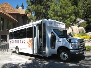 Ein weißer NorthStar-Bus parkt vor einem Gebäude mit einer steinernen Fassade und großen Fenstern.
