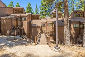 A modern building with multiple units, a central staircase, and a paved walkway. - The Mill Condo 2 Bedroom Townhouse (Truckee)