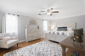 A bedroom with a bed, dresser, chair, and a ceiling fan. - Country Living Near Lake Houston - Starry Skies 3 Bedroom Home (Dayton)