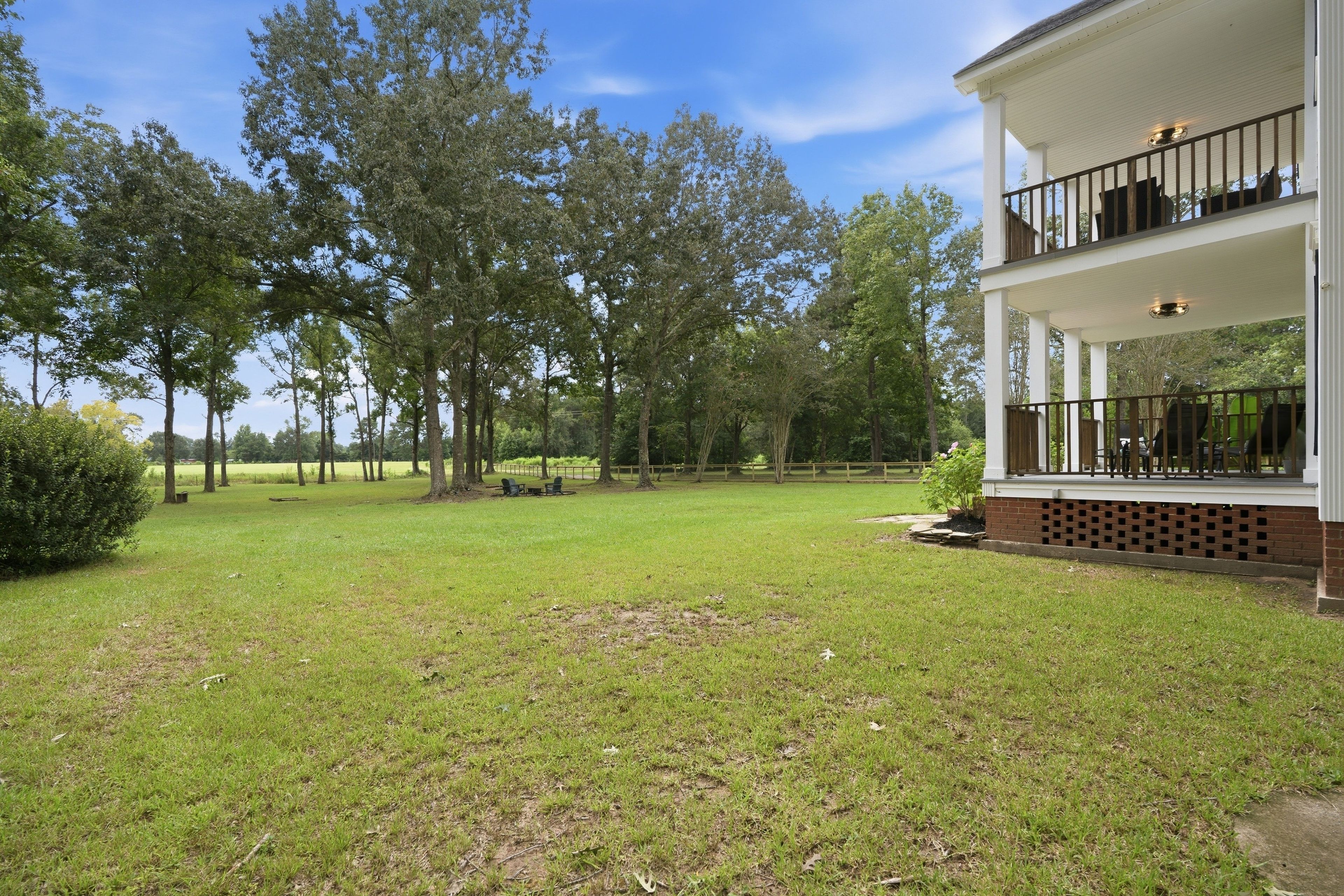 A two-story house with a covered porch and a grassy yard.