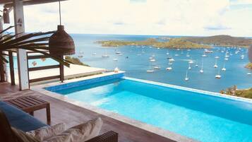 An infinity pool with a view of a marina.