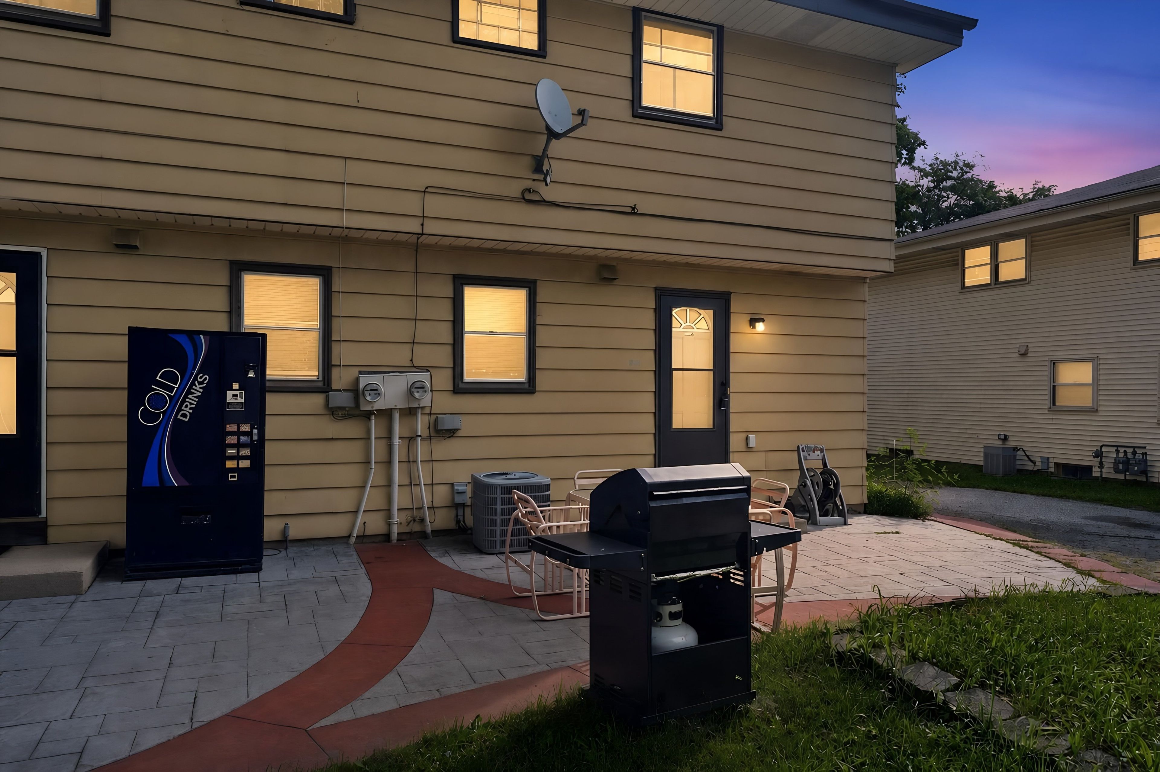 A residential building with a satellite dish, outdoor grill, and a vending machine.