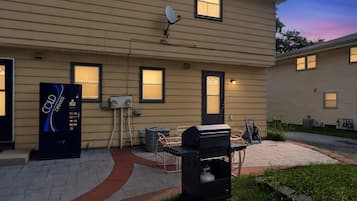 A residential building with a satellite dish, outdoor grill, and a vending machine.