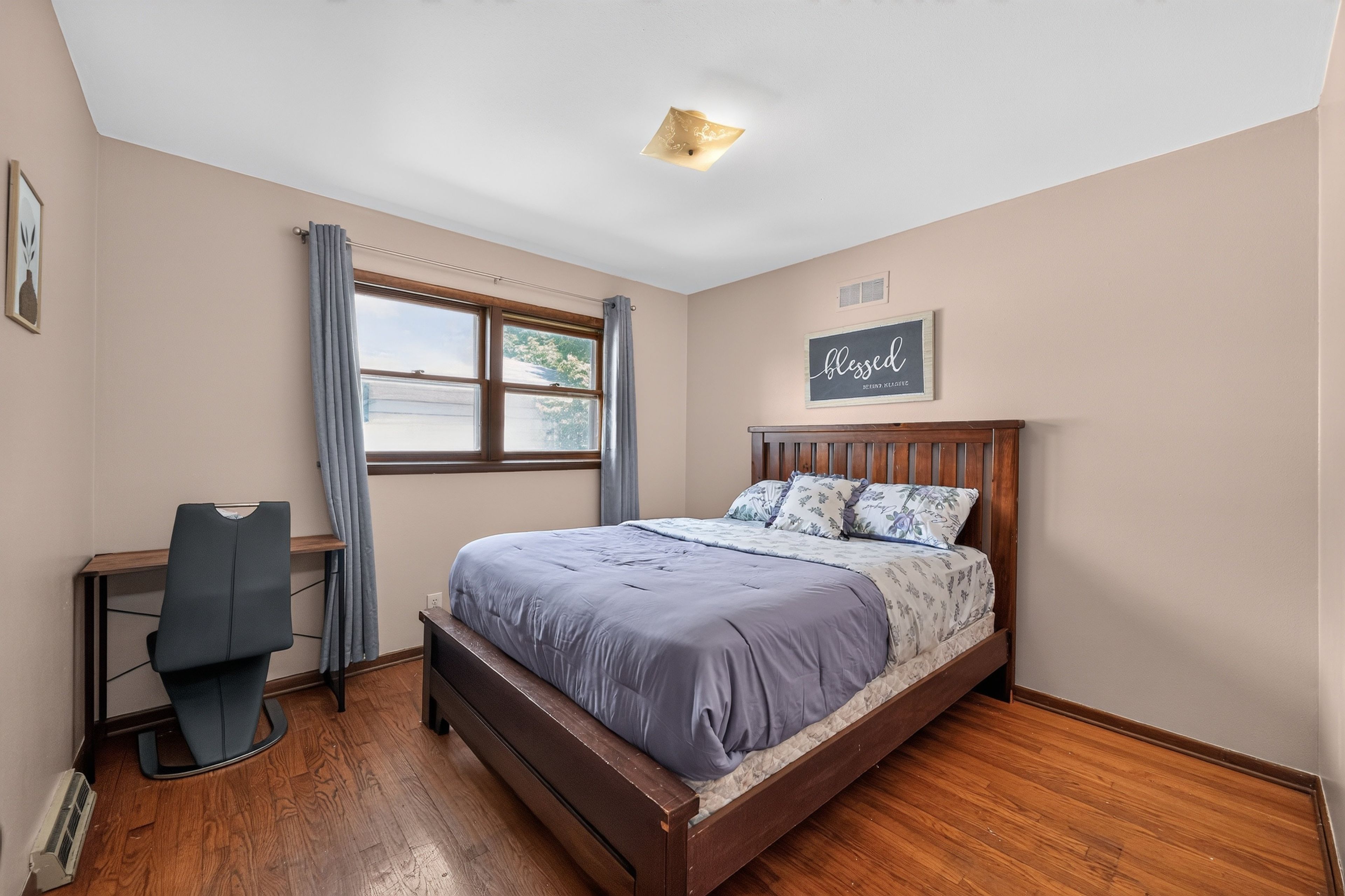 Une chambre à coucher avec un lit, un bureau et une fenêtre.