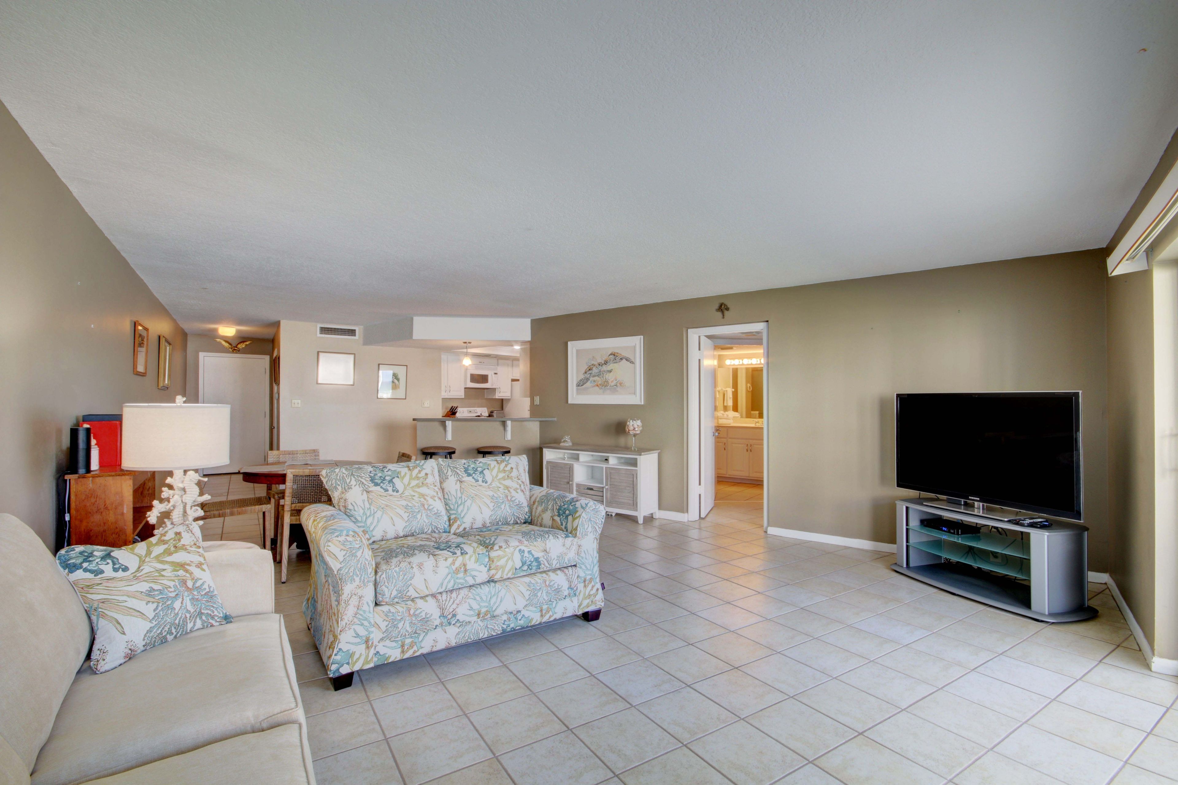 A living room with a sofa, a television, and a dining area with a table and chairs.