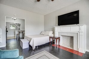 A bedroom with a bed, a television, a fireplace, and a desk area. - San Antonio Studio Near Dining, Pearl District (San Antonio)