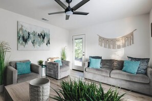 A modern living room with two grey sofas, a coffee table, and a ceiling fan. - 4 Mi to Downtown Austin! Quiet & Quaint Home (Austin)