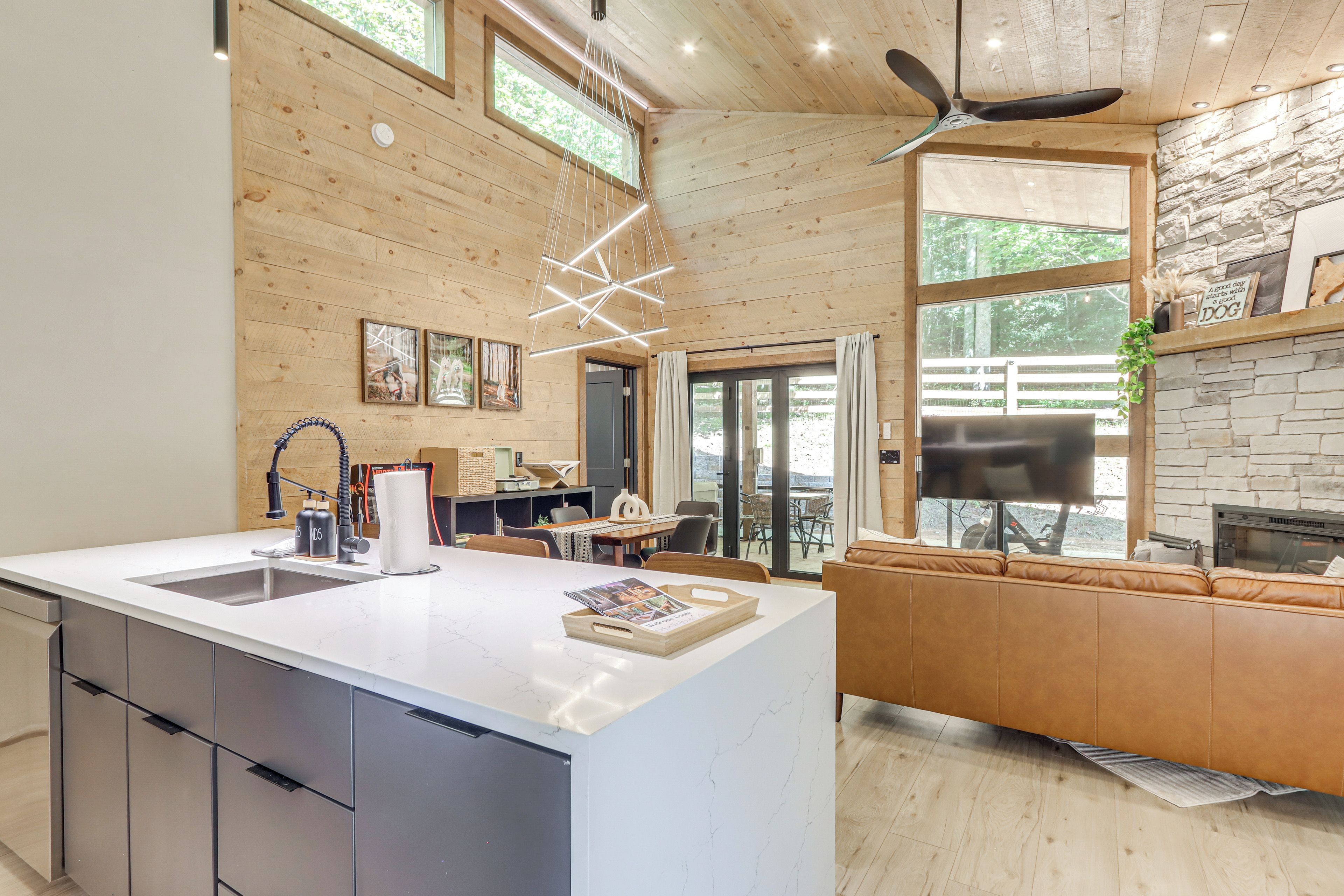 Une cuisine moderne dotée d’un grand îlot central, de meubles en bois et d’une cheminée en pierre.