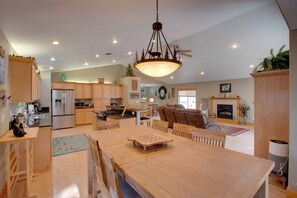 A spacious kitchen with modern appliances, a dining area with a wooden table, and a cozy living room with a fireplace.