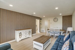 Uma sala de estar moderna com sofá, mesa de centro e área de jantar.