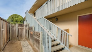 A residential building with a two-story staircase, a red garage door, and a wooden fence. - 1 Mi to Beach! Walkable Extended Base in Monterey (Monterey)