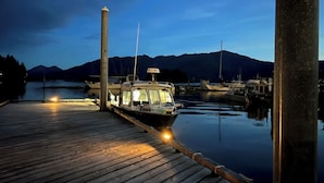 Una barca ormeggiata in una marina, con acque calme e montagne sullo sfondo.