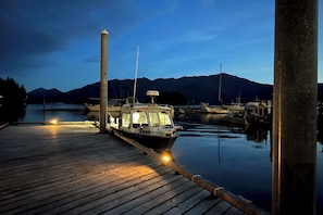 A docked boat at a marina with calm water and mountains in the background. - Ketchikan Beach Retreat Dock On-site (Ketchikan)