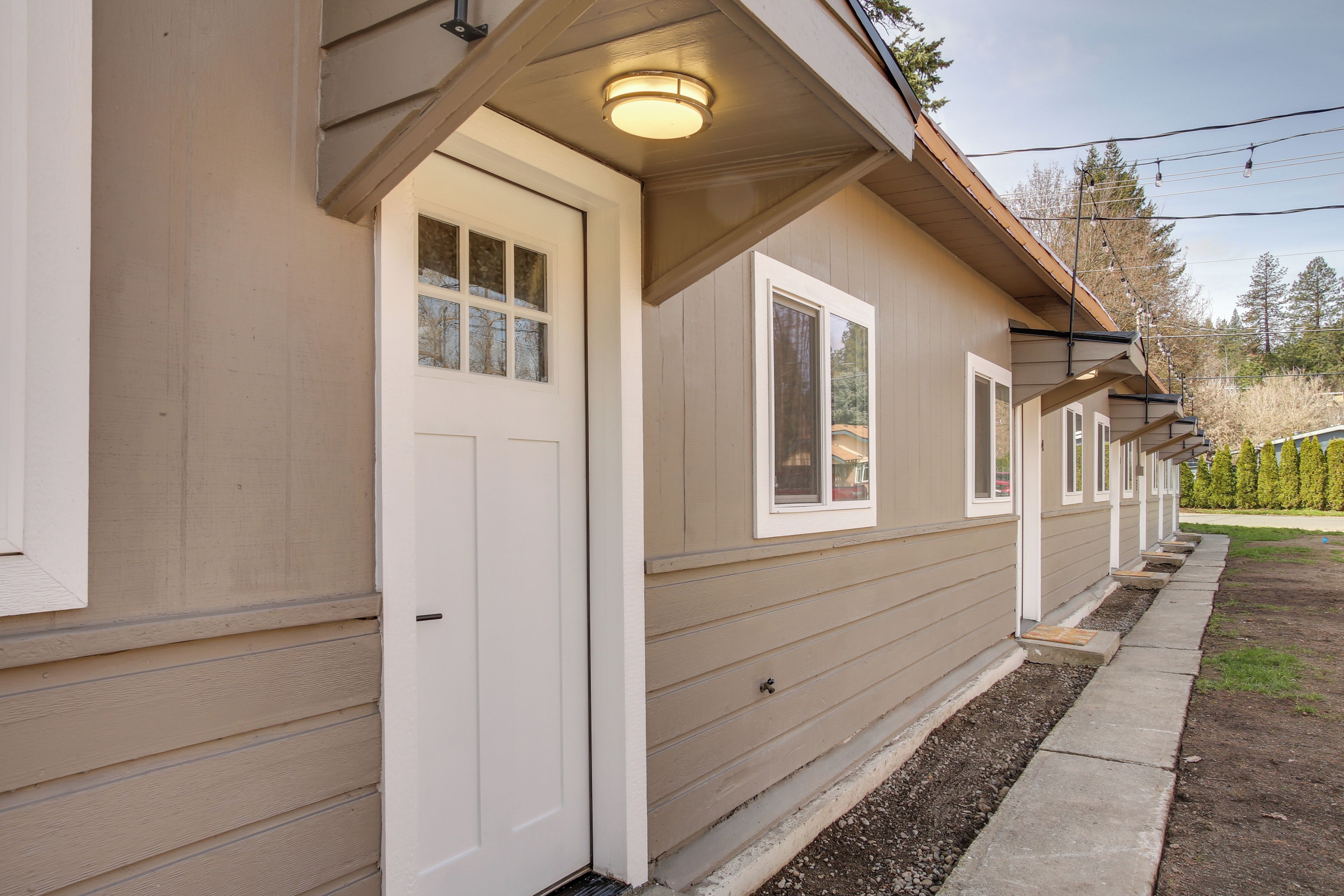A row of single-story buildings with a consistent architectural style, featuring a flat roof, a front door with a window, and a small porch area.