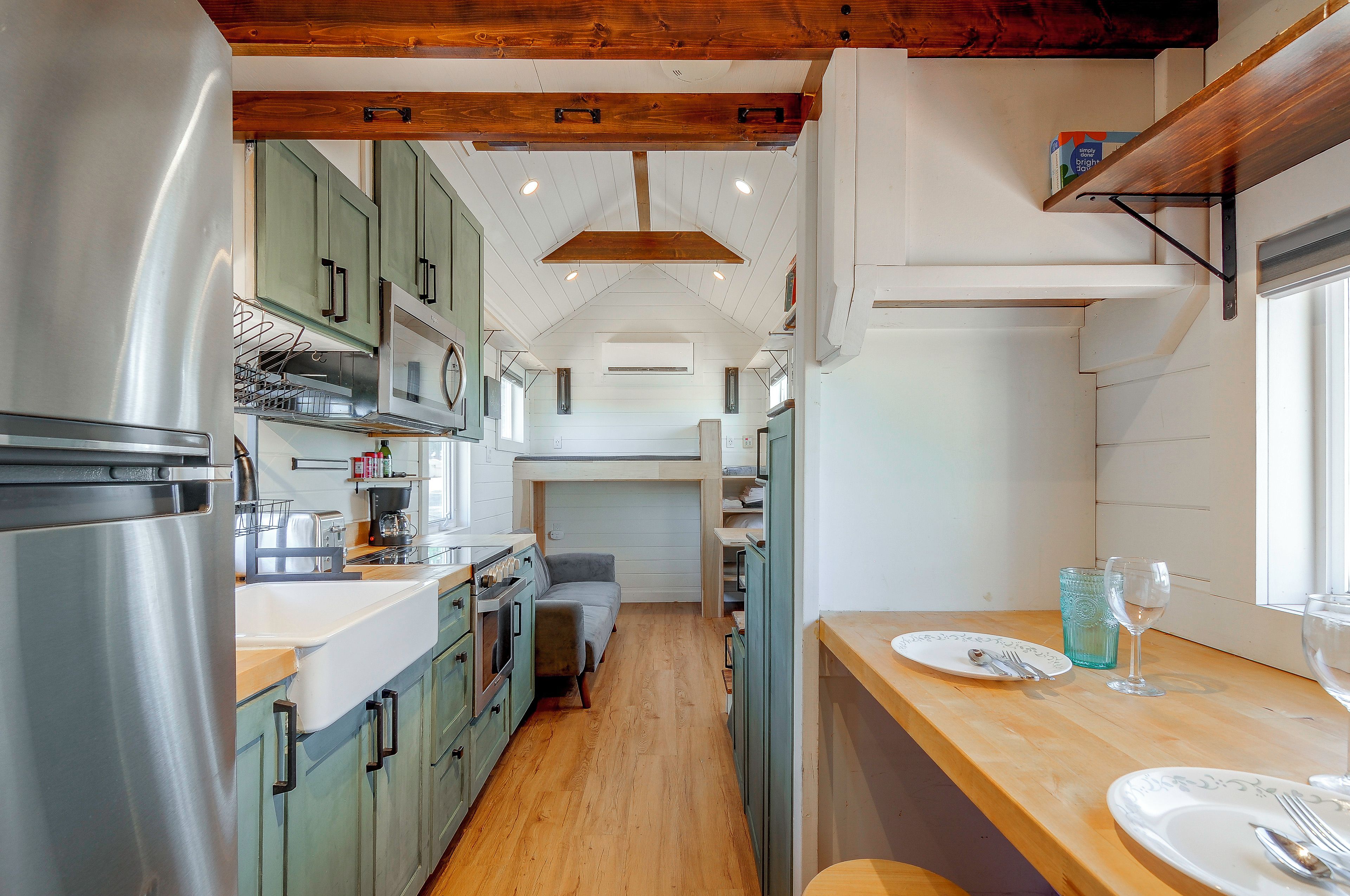 A compact kitchen with modern appliances, a dining area with a table set for two, and a cozy seating area.