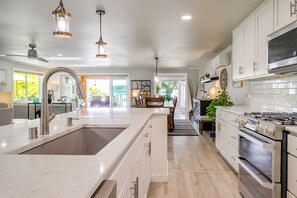 A modern kitchen with a central island, stainless steel appliances, and pendant lighting. - Waterfront Whidbey Island Oasis! Hot Tub + Patio (Freeland)