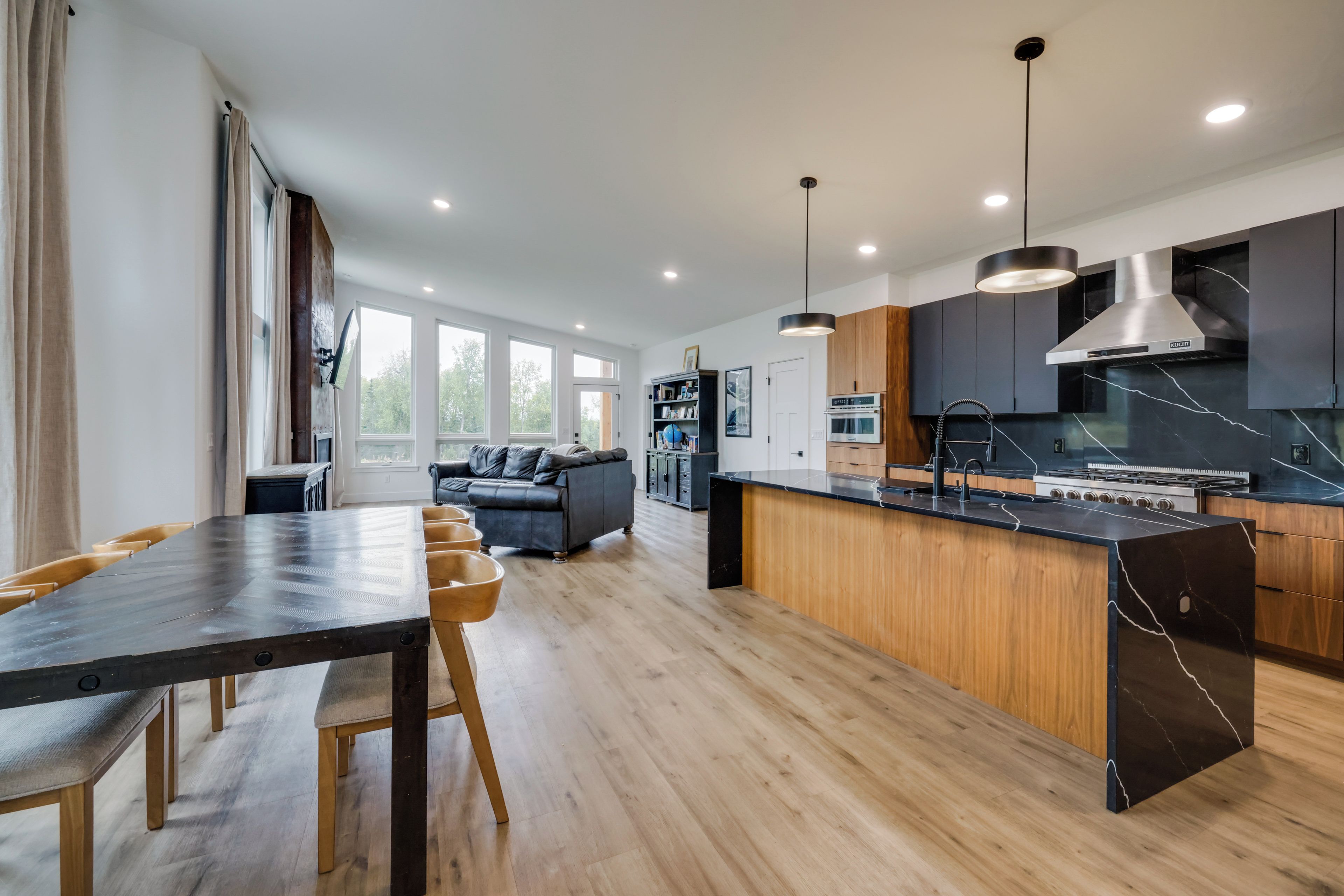 Una cocina moderna con una isla central, armarios de madera y un horno empotrado.