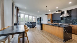Una cocina moderna con una isla central, armarios de madera y un horno empotrado.