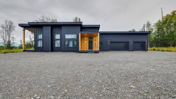 A modern two-story building with a gravel driveway.