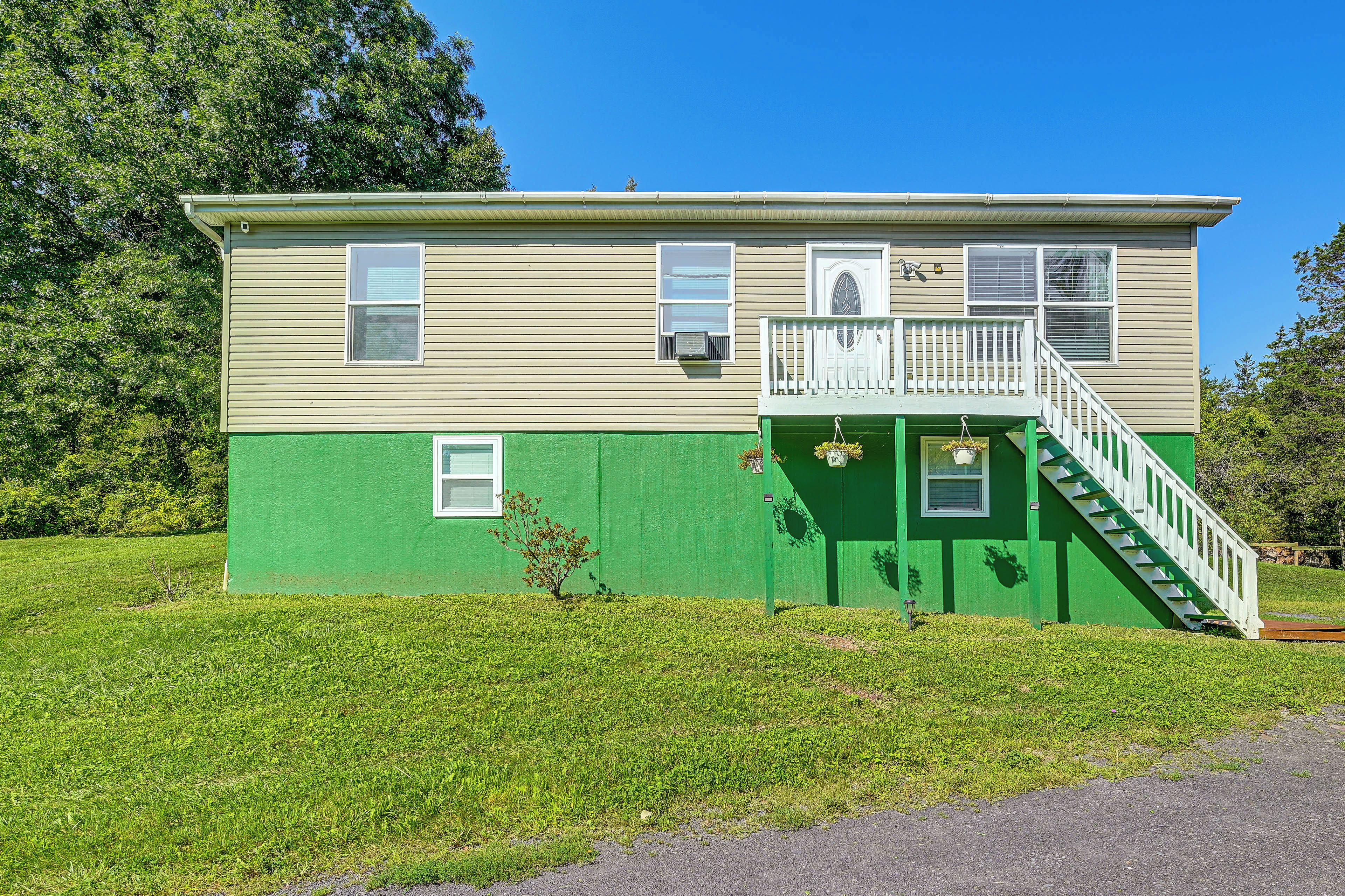 A two-story house with a green front and a white balcony.