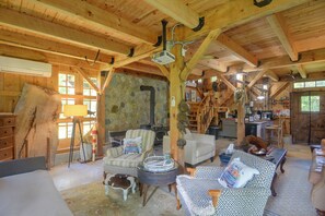 A rustic interior with wooden beams, stone walls, and a cozy seating area with a fireplace. - Fire Pit, Deck! Rural Retreat Near East Beach (Charlestown)